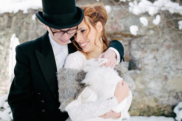 Bride and groom holding rabbit