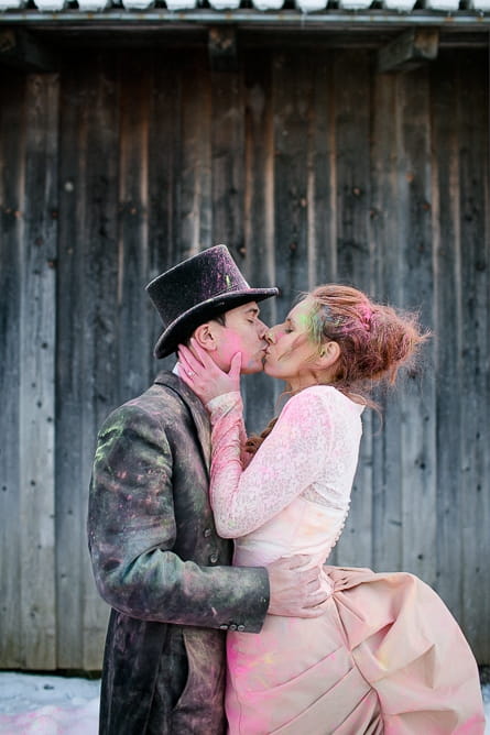 Bride and groom kiss covered in holi powder