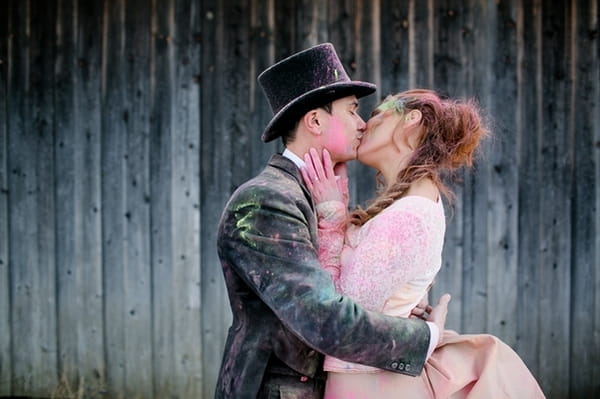 Bride and groom kiss covered in holi powder