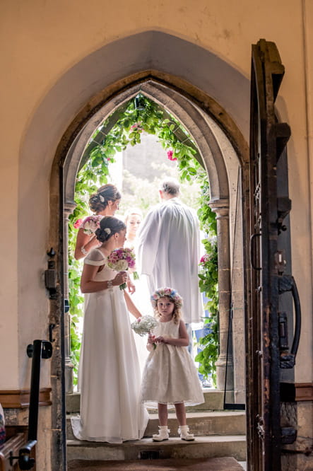 Bridesmaids and flower girl at church entrance