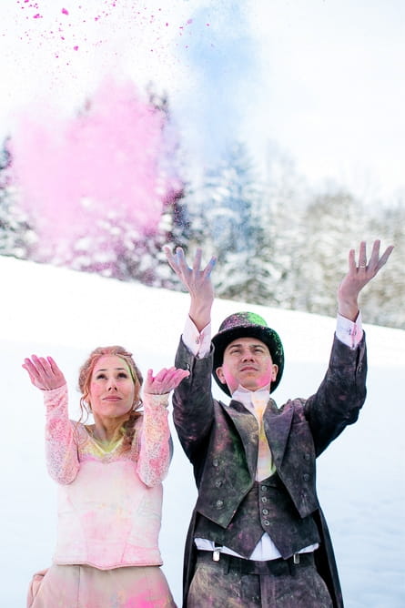 Bride and groom throwing holi powder in the air