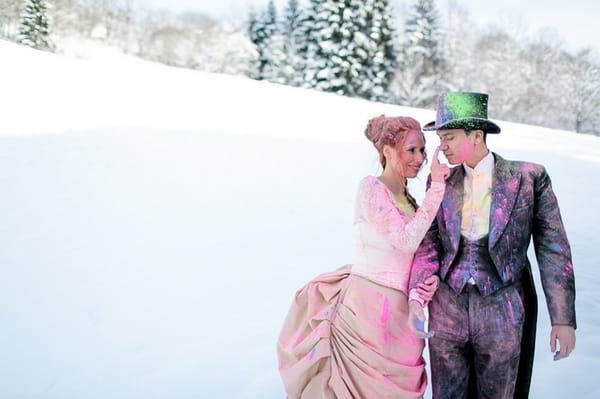 Bride and groom covered in holi powder in the snow