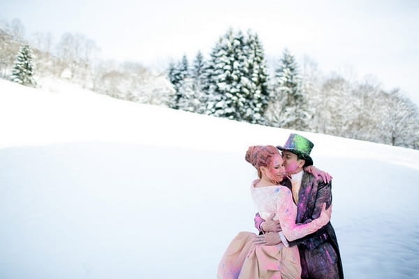 Bride and groom covered in holi powder in the snow