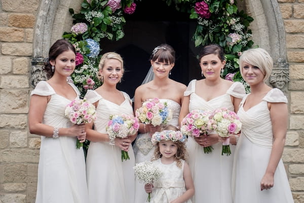 Bride and bridesmaids standing at entrance to church