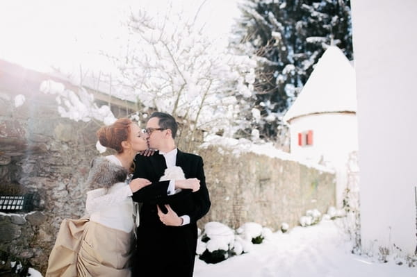 Bride and groom kissing whilst holding rabbit