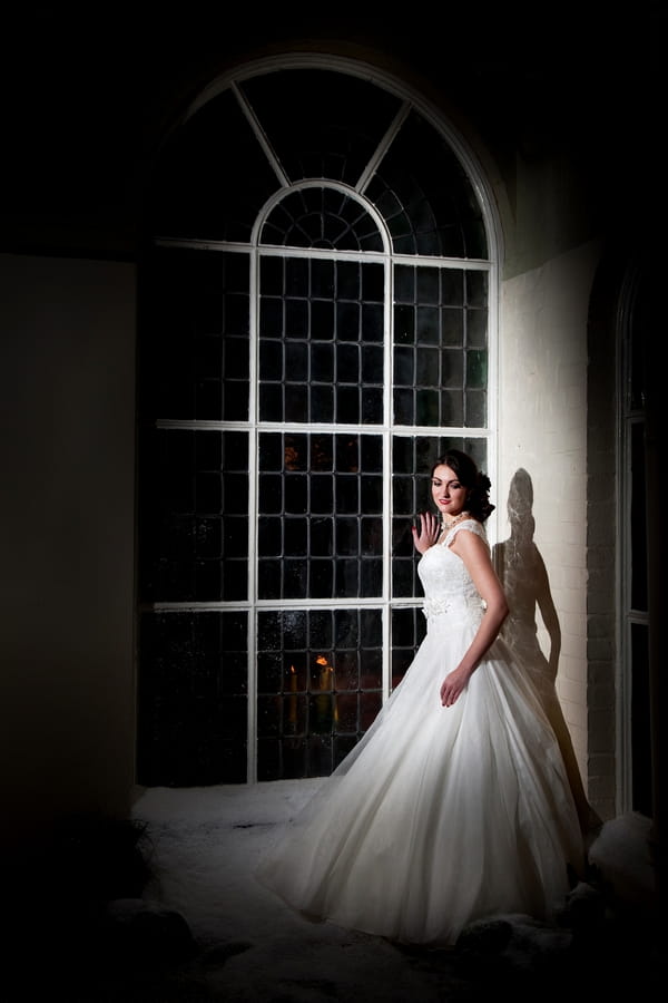 Bride standing by window