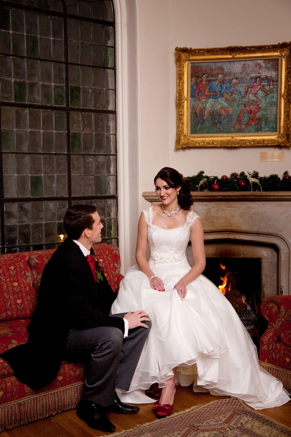 Bride and groom sitting by fire