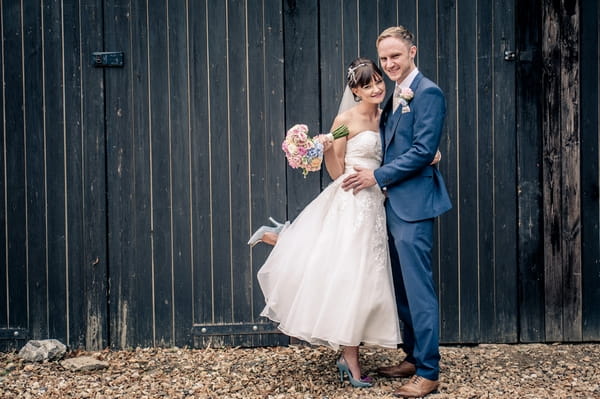 Bride and groom in front of barn doors