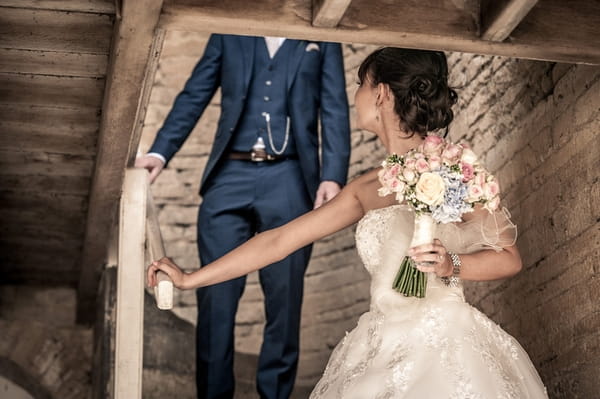 Bride walking down steps looking back at groom