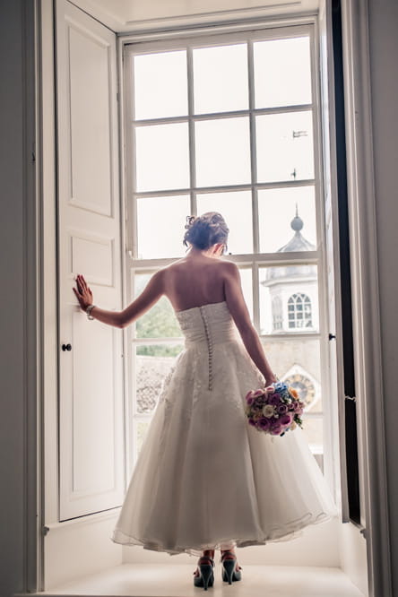 Bride standing at window