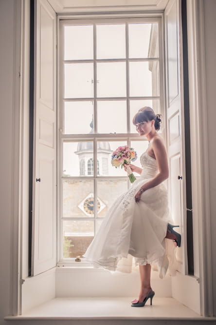 Bride standing at window