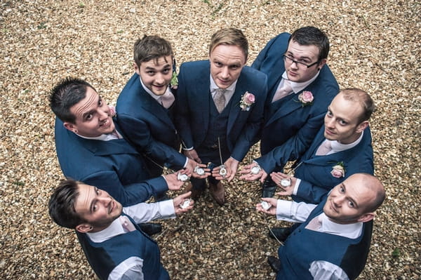 Groomsmen holding pocket watches