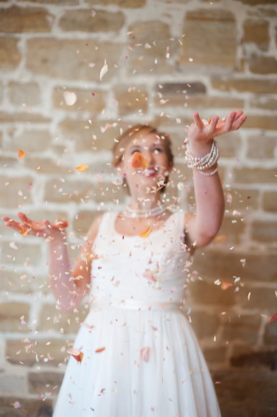 Bride throwing confetti in air