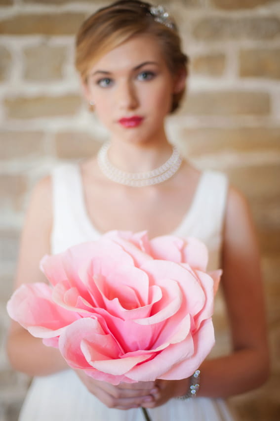 Bride holding large pink flower