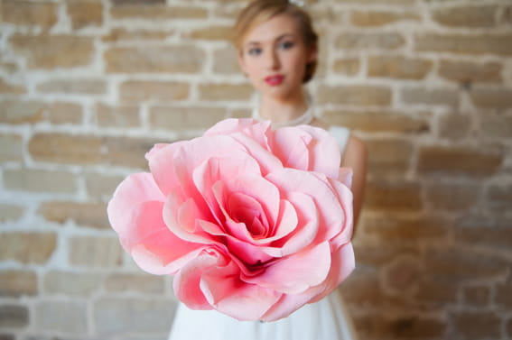 Bride holding large pink flower