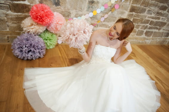 Bride sitting holding paper pom pom