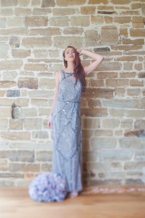 Bride standing in front of wall with hand behind head