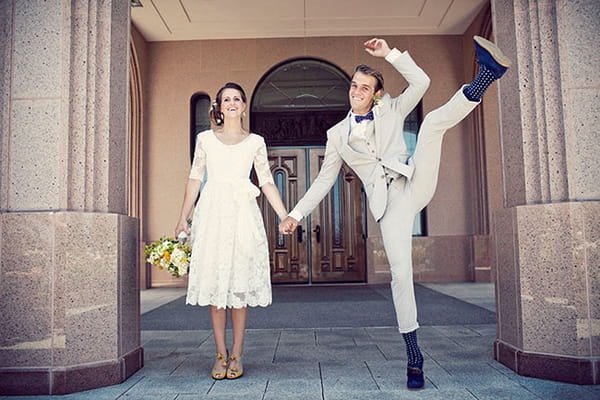 Bride with groom kicking his leg up in air