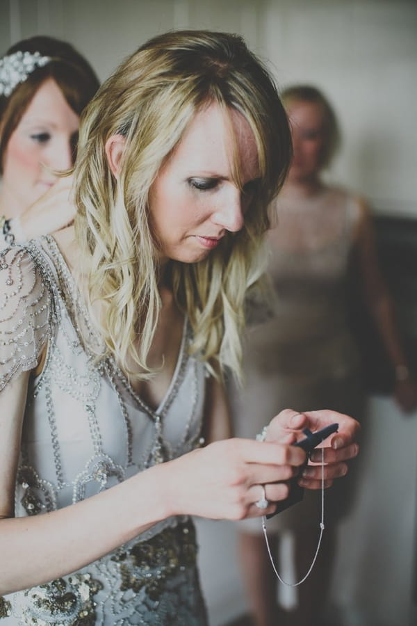 Bride holding necklace