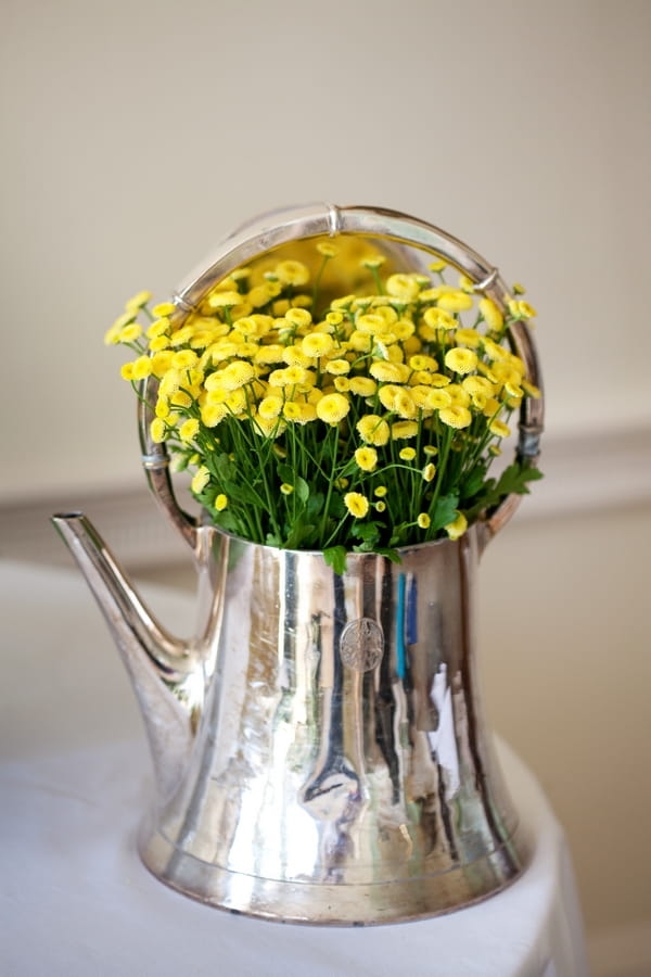 Silver teapot of yellow flowers