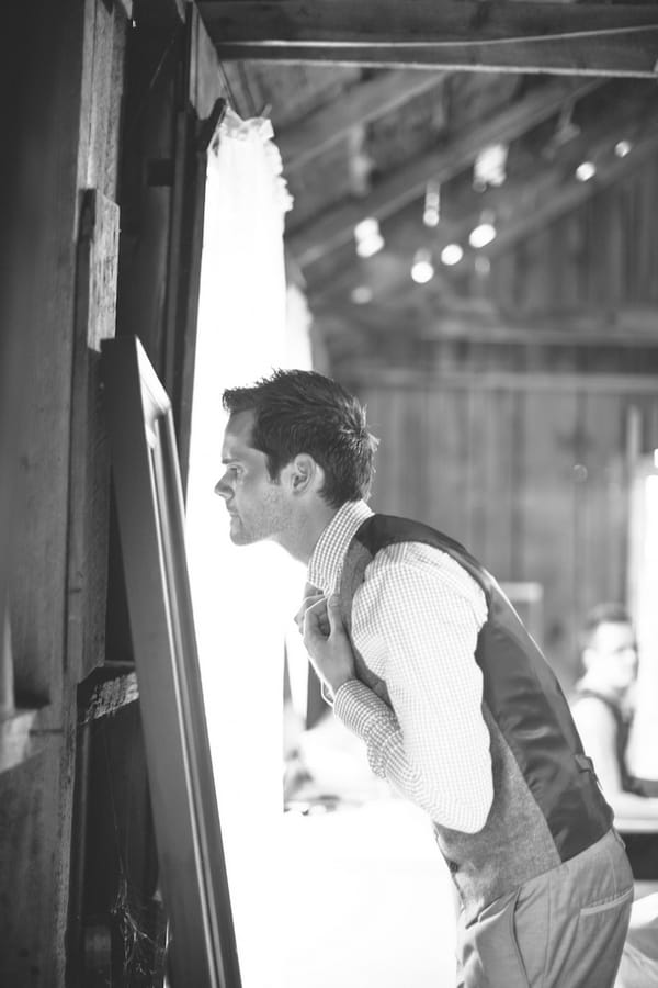 Groom doing tie in mirror