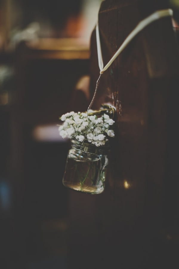 Jar of flowers at end of church pew