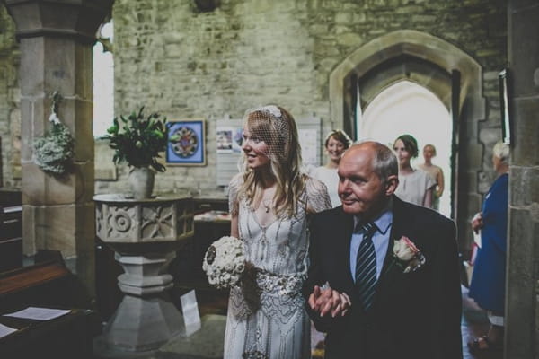 Bride walking into church with father