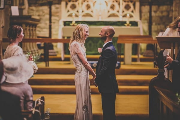 Bride and groom holding hands in wedding ceremony