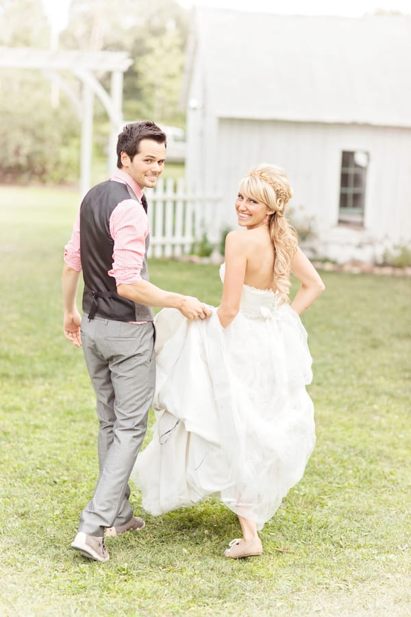 Groom holding up bride's dress