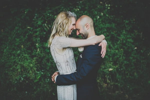 Bride and groom resting heads on each other