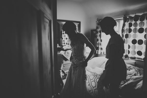 Bride putting dress on