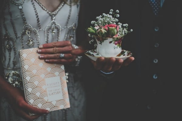 Bride and groom holding book and teacup