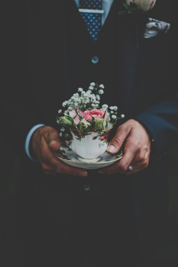 Groom holding vintage teacup