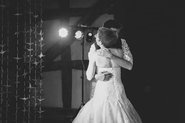 Bride and groom hug on dance floor