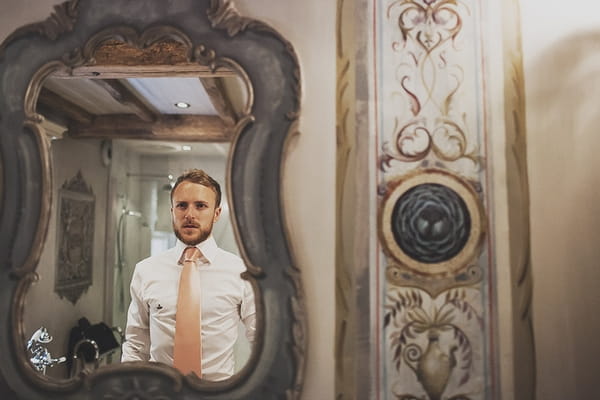 Groom looking in mirror