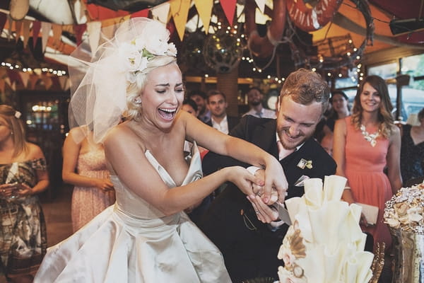 Bride and groom cutting wedding cake