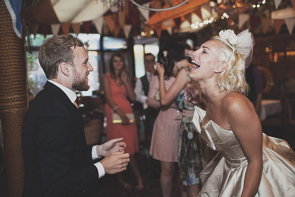 Bride and groom laughing on dance floor