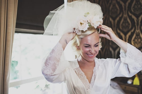 Bride putting on veil