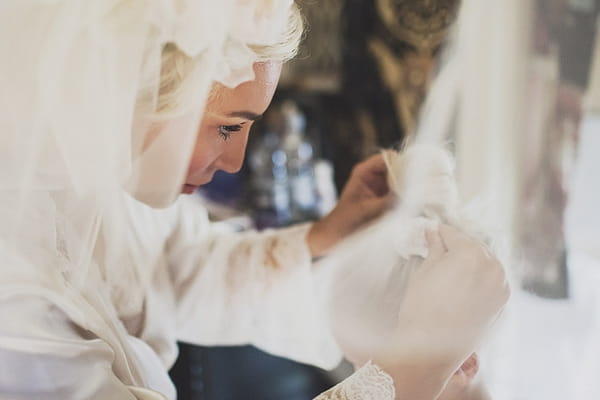 Bride putting flower in young girl's hair