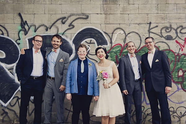 Wedding party in front of graffiti wall