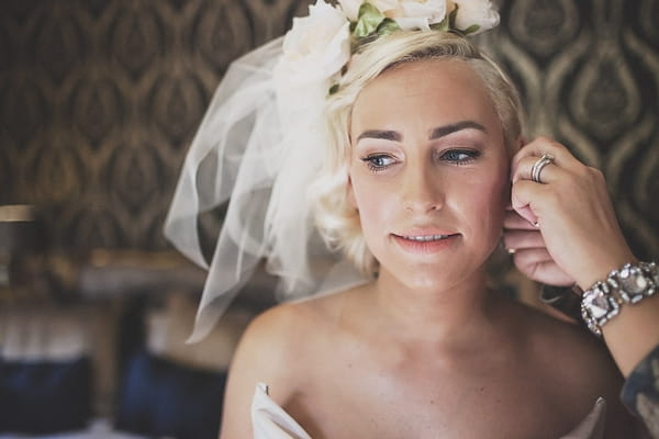 Bride putting earrings on