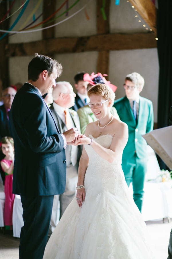 Groom putting ring on bride's finger