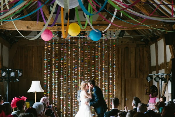 Bride and groom kiss in wedding ceremony