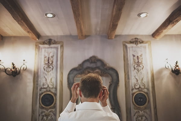 Groom doing hair in mirror