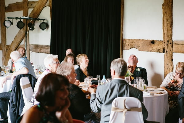 Wedding guests laughing at speech