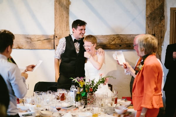 Groom with arm around bride