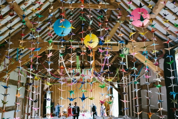 Colourful decorations hanging from ceiling at wedding