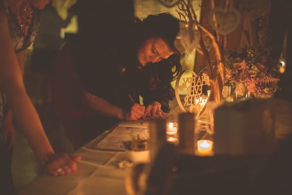 Wedding guests writing in guest book