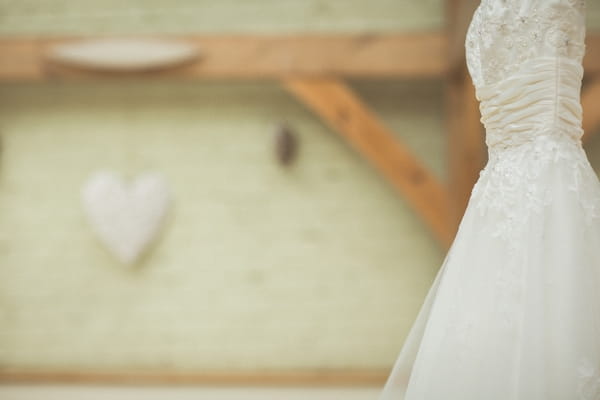 Wedding dress hanging from beam