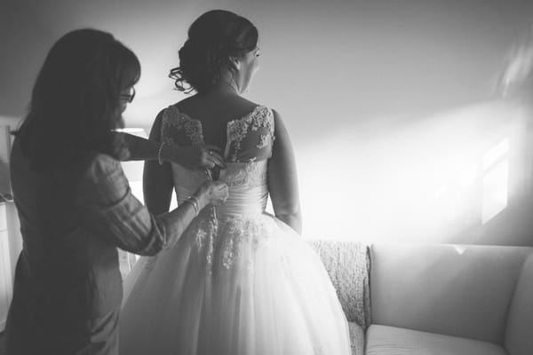 Bride putting wedding dress on